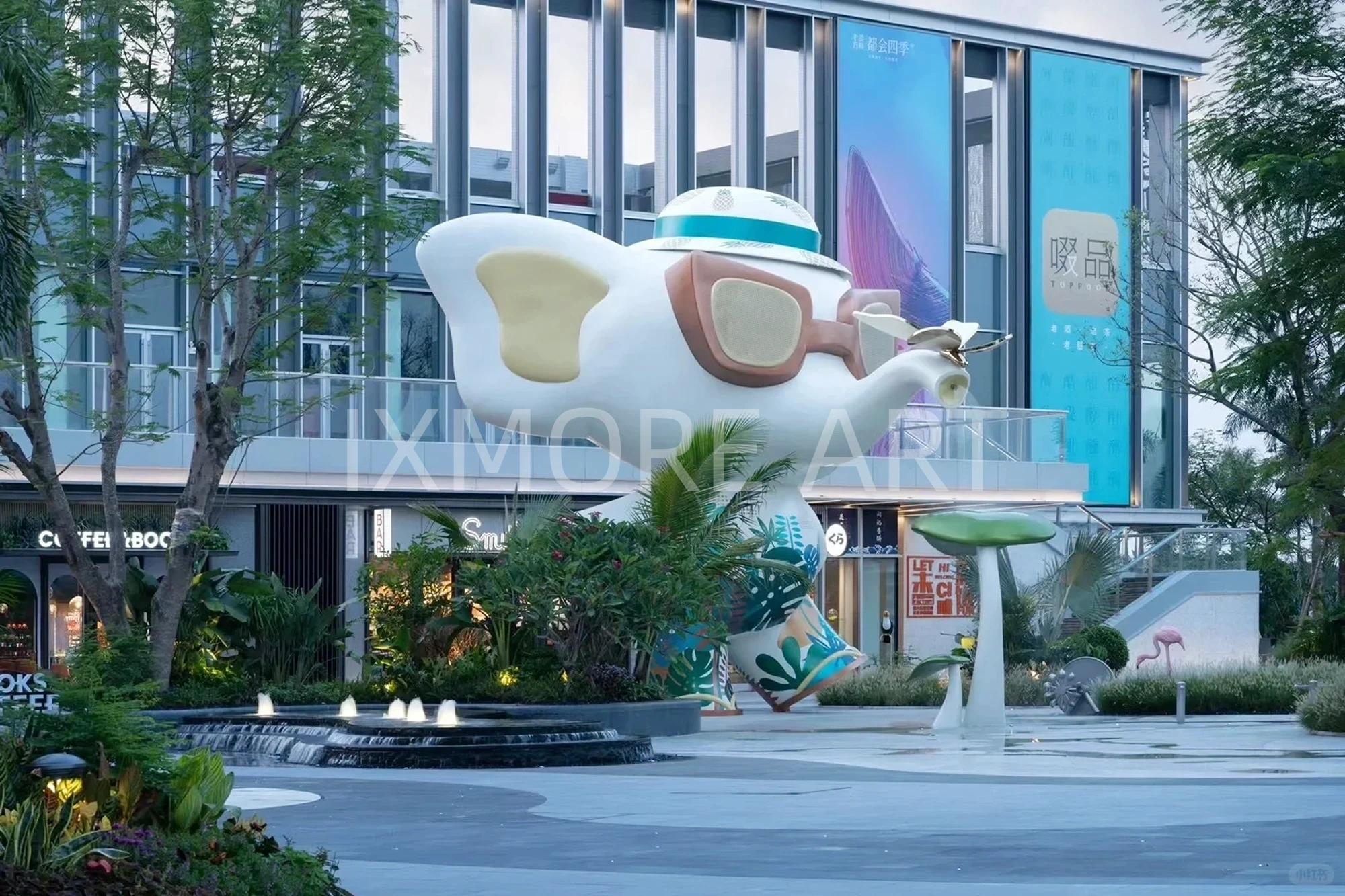 Long shot of Tropical Baby Elephant IP sculpture outside mall, mist spray dynamic device customized by professional art factory, overall finished effect of large outdoor public art installation(1)