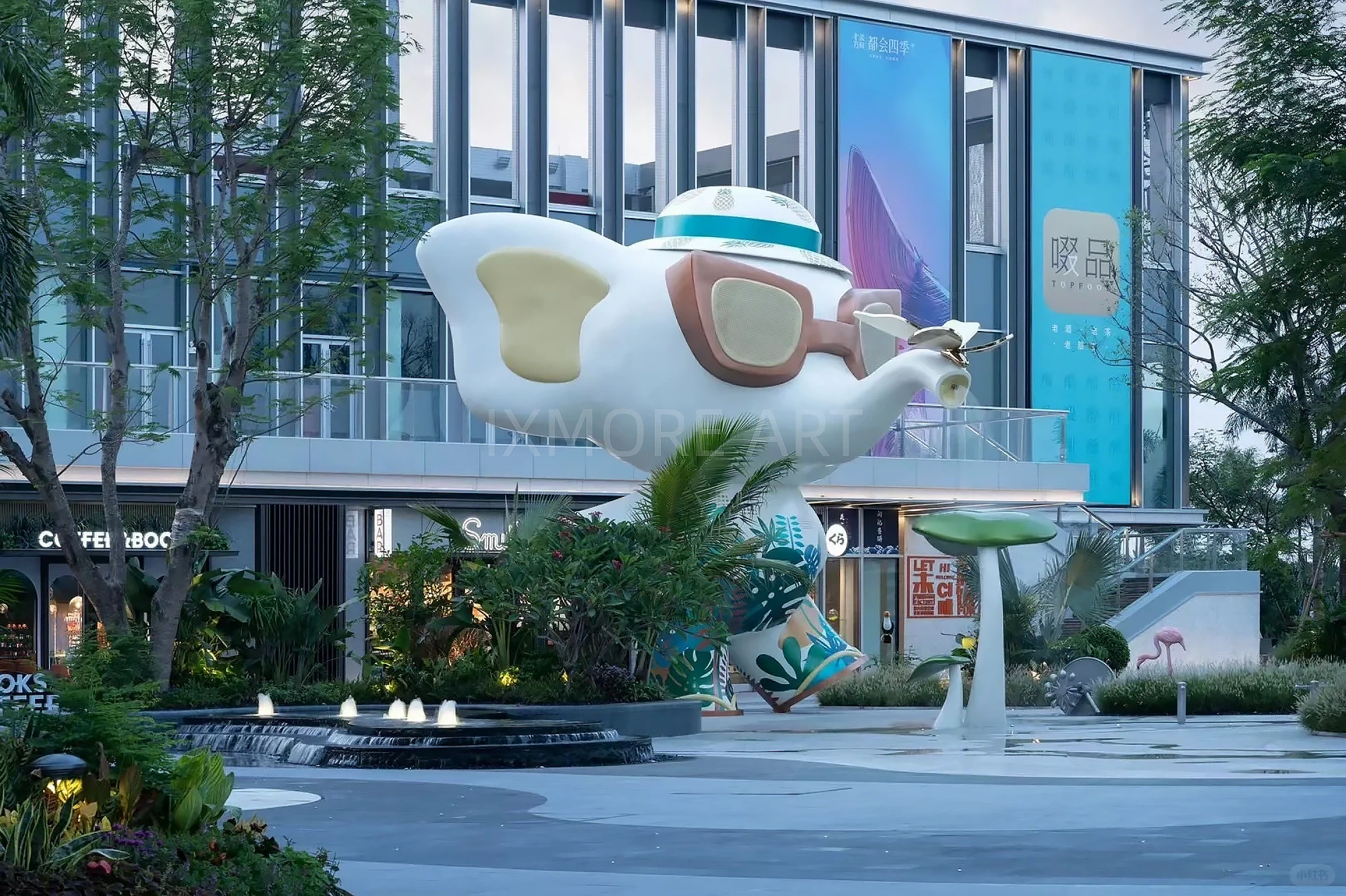 Long shot of Tropical Baby Elephant IP sculpture outside mall, mist spray dynamic device customized by professional art factory, overall finished effect of large outdoor public art installation(1)