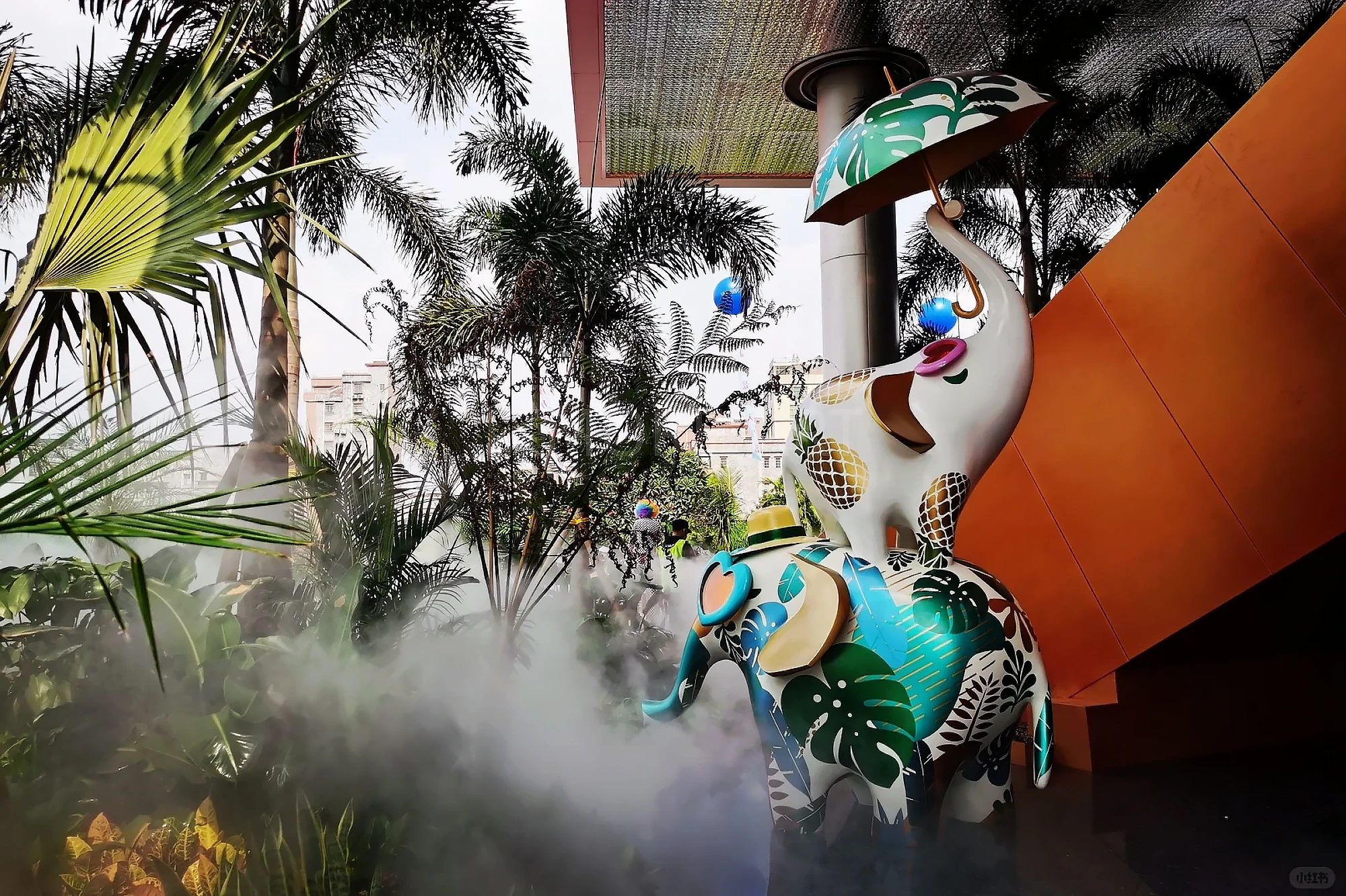 Long shot of Tropical Baby Elephant IP sculpture outside mall, mist spray dynamic device customized by professional art factory, overall finished effect of large outdoor public art installation(3)