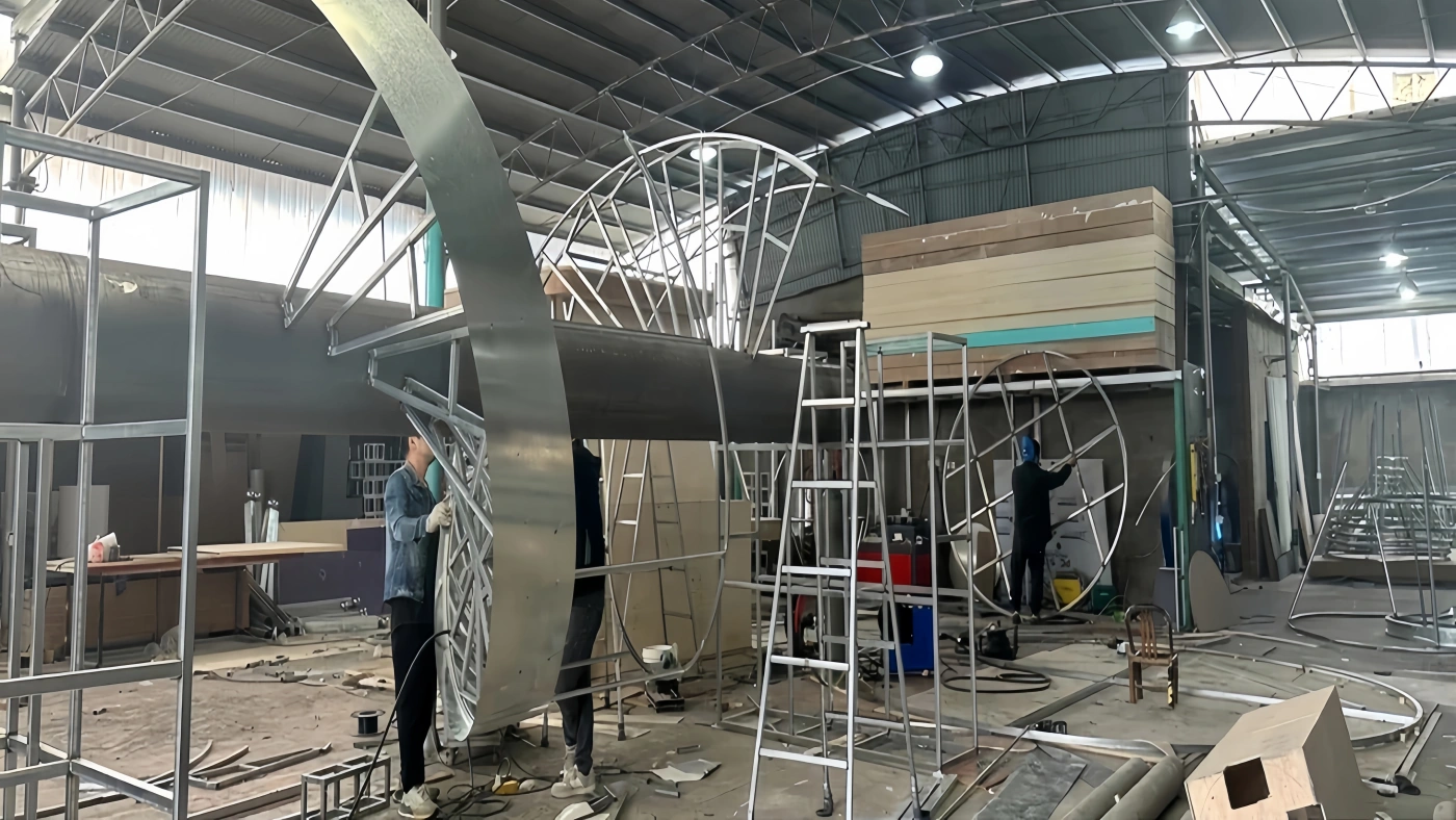Workers fabricating modular steel structures and electrical systems for custom shopping mall installations